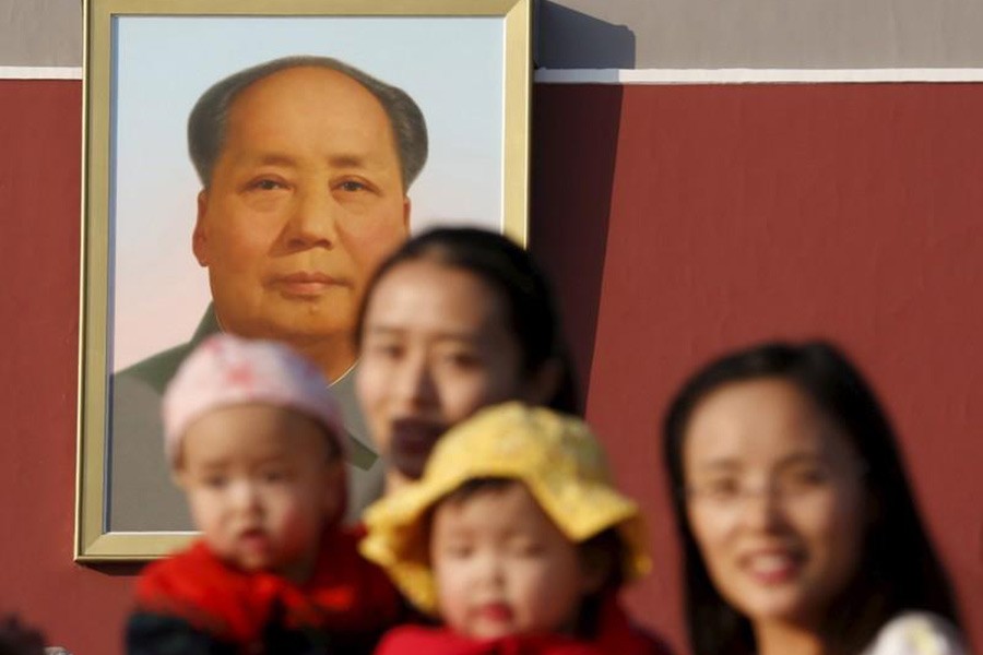 Two women and their babies posing for photographs in front of the giant portrait of late Chinese chairman Mao Zedong on the Tiananmen Gate in Beijing November 2, 2015. -Reuters Photo