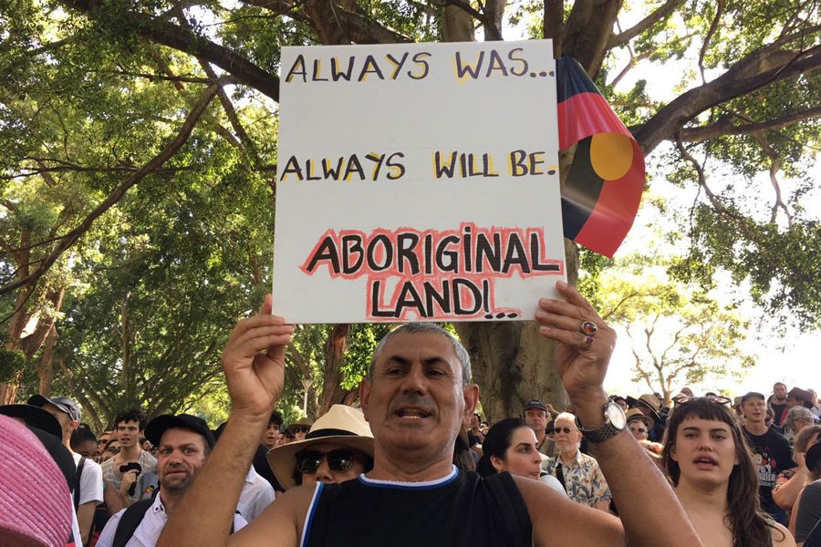 A man holds up a placard during a demonstration on Australia Day in Sydney, January 26, 2019 - REUTERS/Stefica Nicol Bikes