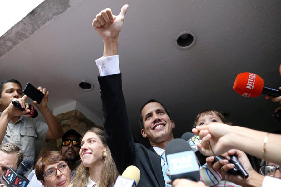 Venezuelan opposition leader and self-proclaimed interim president Juan Guaido reacts next to his wife Fabiana Rosales and while carrying his daughter outside their home, after a meeting with supporters to present a government plan of the opposition in Caracas, Venezuela January 31, 2019. Reuters