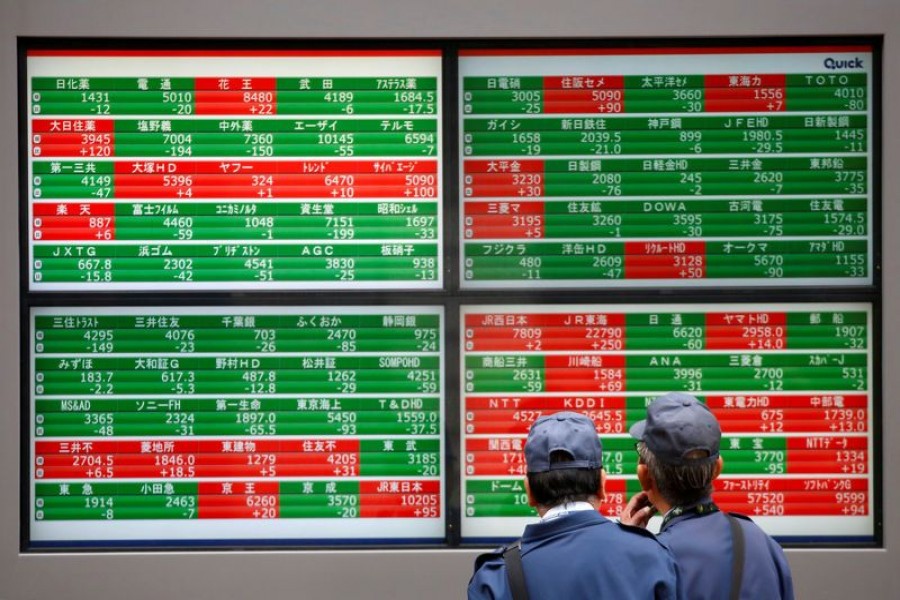 Men look at stock quotation boards outside a brokerage in Tokyo, Japan, December 5, 2018. Reuters/Files