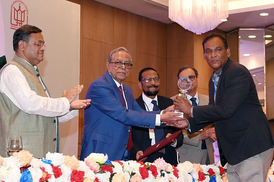 Jasim Uddin Haroon, a special correspondent of The Financial Express, receiving the Press Council Award in Development Journalism category from President Abdul Hamid at a ceremony in Dhaka on Monday. -PID Photo