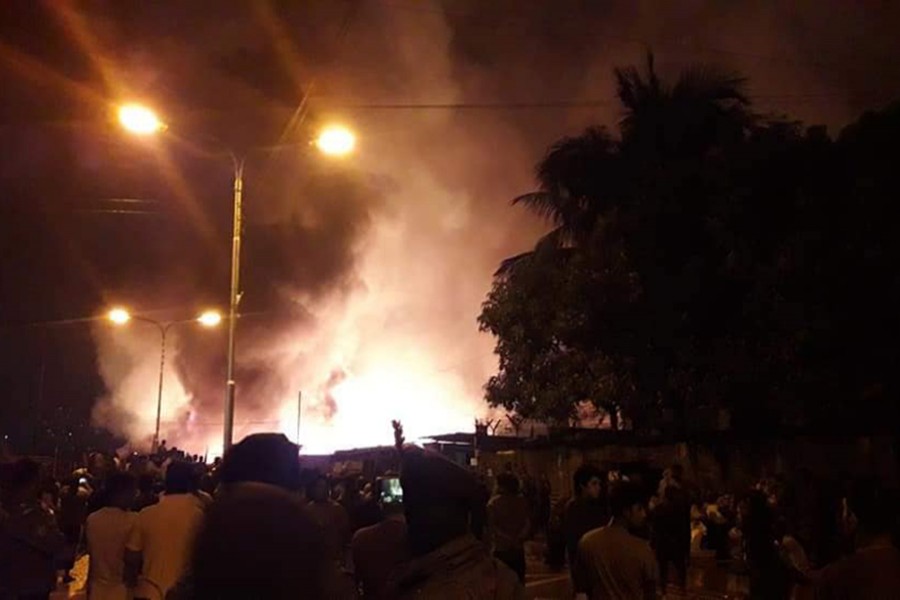 Onlookers watch a fire which broke out at a slum in capitals Bhashantek area in the early hour of Thursday — Photo via Facebook