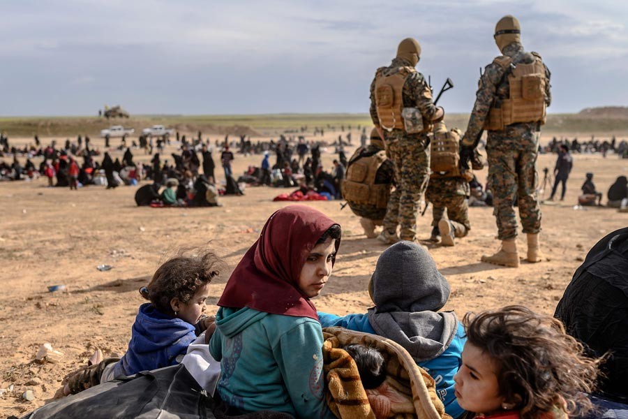 BAGHOUZ: Civilians waiting at a screening area held by the US-backed Kurdish-led Syrian Democratic Forces (SDF), in Baghouz area on Wednesday	— AFP