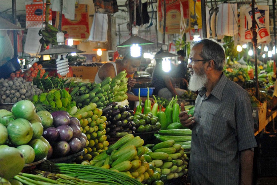 A potential customer seen bargaining vegetable prices at Plassey Bazar in the capital Dhaka in this undated Focus Bangla photo