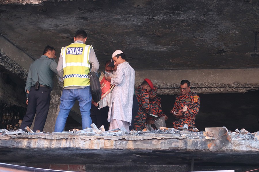 Fire Serivice officials along with policemen inspect the site of a deadly blaze at Churihatta in Old Dhaka’s Chawkbazar that resulted in the deaths of at least 71 people — FE/file