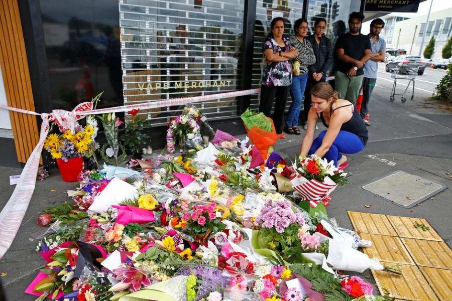 People place flowers at a memorial as a tribute to victims of the mosque attacks, near Linwood mosque in Christchurch, New Zealand, March 16, 2019 - Reuters