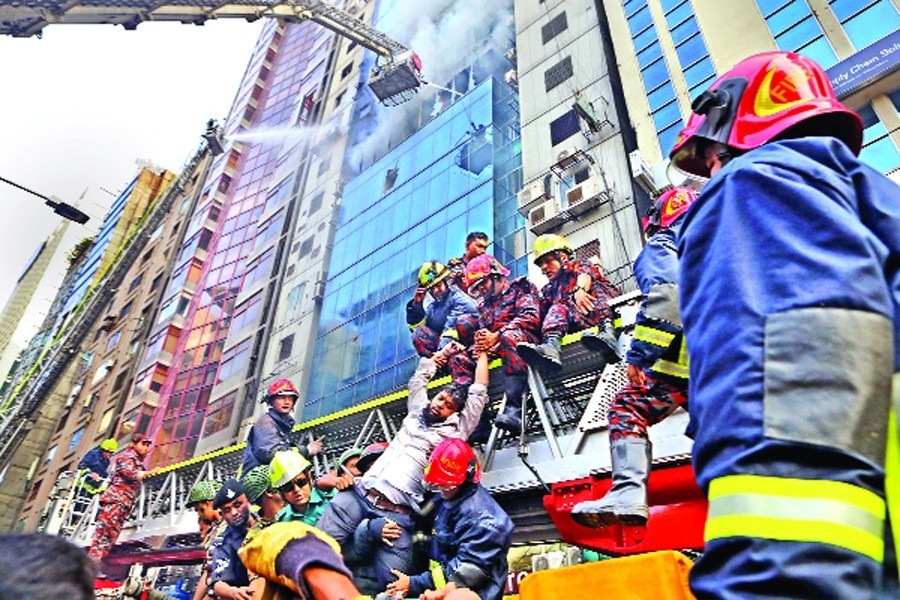 Fire-fighters rescuing a person after a blaze raged through several floors of FR Tower at Banani in the capital on Thursday	— FE Photo by Shafiqul Alam