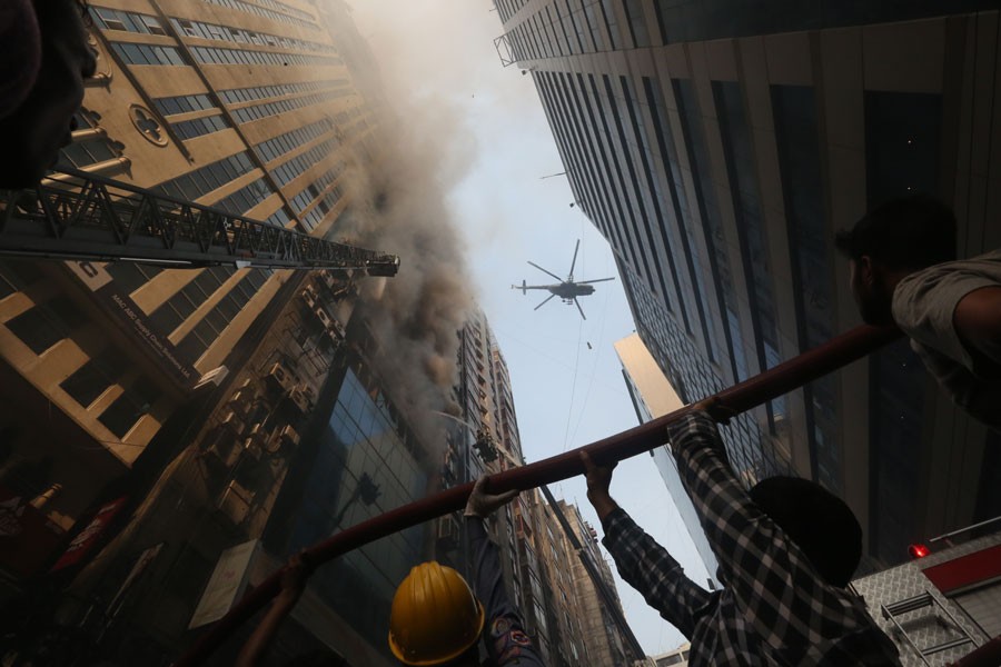 A helicopter is seen hovering right over the FR Tower, which caught fire, in Dhaka's Banani on Thursday, as Bangladesh Air force join others to rescue trapped people and fight the blaze. FE Photo