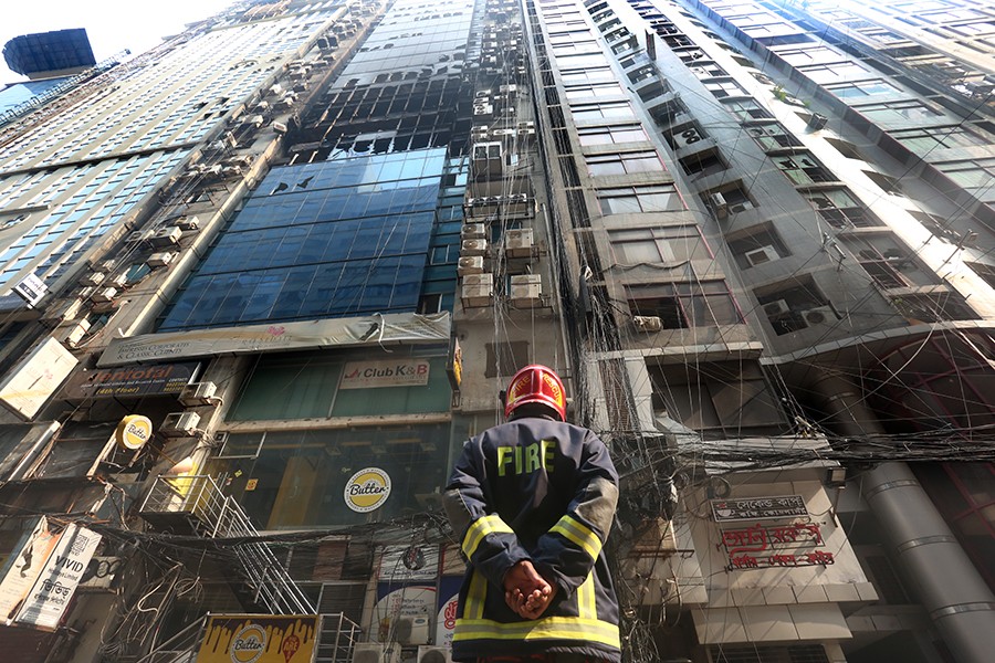 A firefighter stands outside the FR tower at Banani after putting out a deadly blaze that tore through several floors of the skyscraper, killing at least 25 people — FE photo