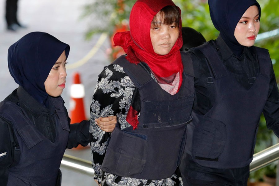 Vietnamese Doan Thi Huong, centre, is escorted by police as she arrives at Shah Alam High Court in Shah Alam, Malaysia, Thursday, March 14, 2019. Vietnam has urged Malaysia to release the second woman accused of killing the estranged half brother of North Korea's leader after her co-defendant was unexpectedly set free - AP Photo/Vincent Thian