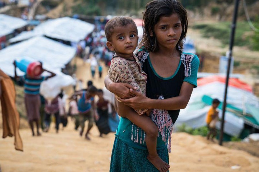 A young child clutches her younger brother as she looks for her family in the Kutupalong makeshift camp in Ukhia, Cox's Bazar, October 24, 2017. Reuters/Files