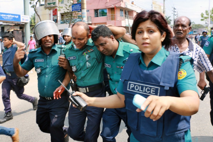 An injured policeman being helped walk off after coming under attack during clashes with jute mill workers in Khulna on Thursday — Focus Bangla photo