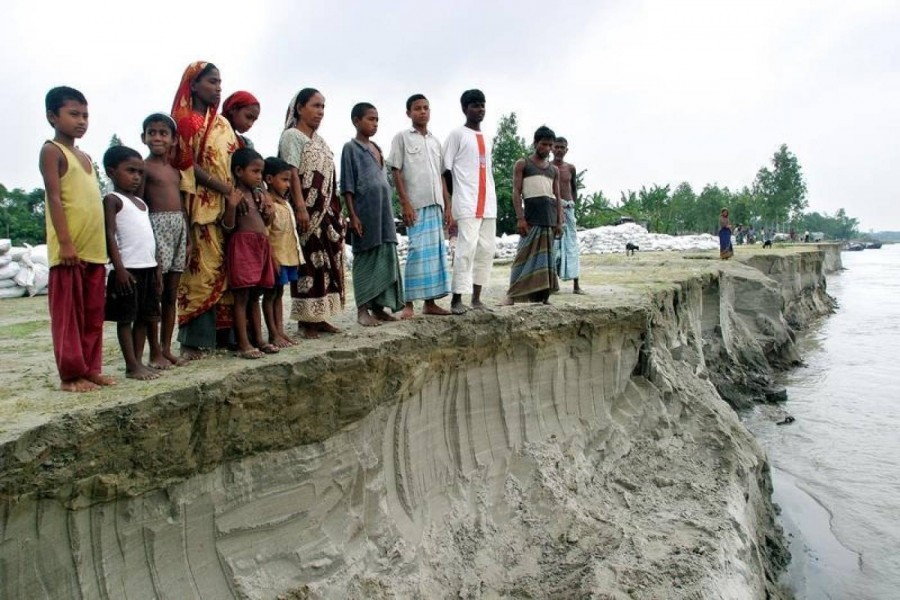 In this July 2004 file photo, Bangladeshis look at the erosion left by the river Jamuna, in Sariakandi, near Bogra town, 250 km northwest of the capital Dhaka. Reuters