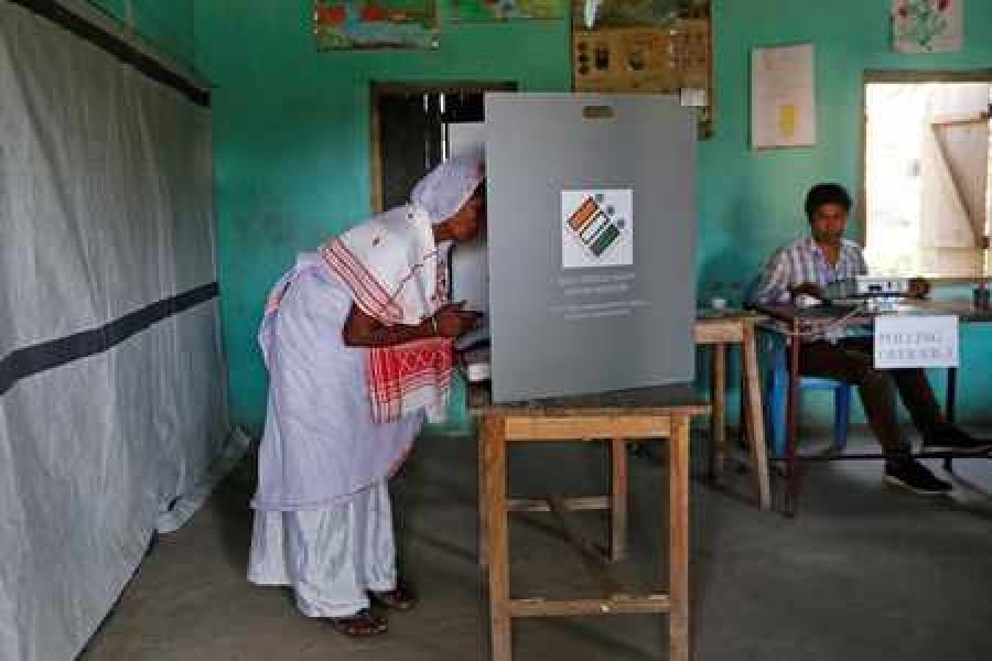 A woman casts her vote at a booth next to a polling officer at a polling station in Majuli, a large river island in the Brahmaputra river, in the northeastern Indian state of Assam, India, April 11, 2019. Reuters