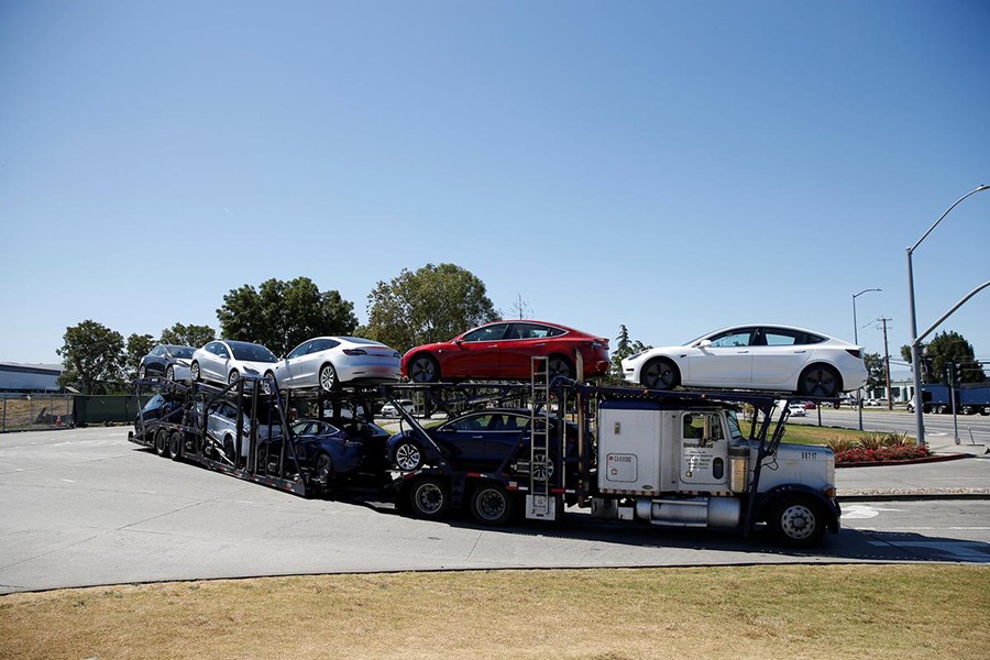 A car carrier trailer carries Tesla Model 3 electric sedans, is seen outside the Tesla factory in Fremont, California, US on June 22, 2018 — Reuters photo