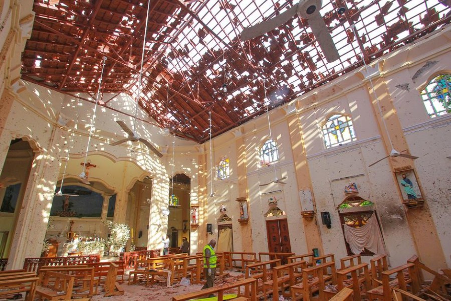 A crime scene official inspects the site of a bomb blast inside a church in Negombo, Sri Lanka April 21, 2019 - REUTERS/Stringer