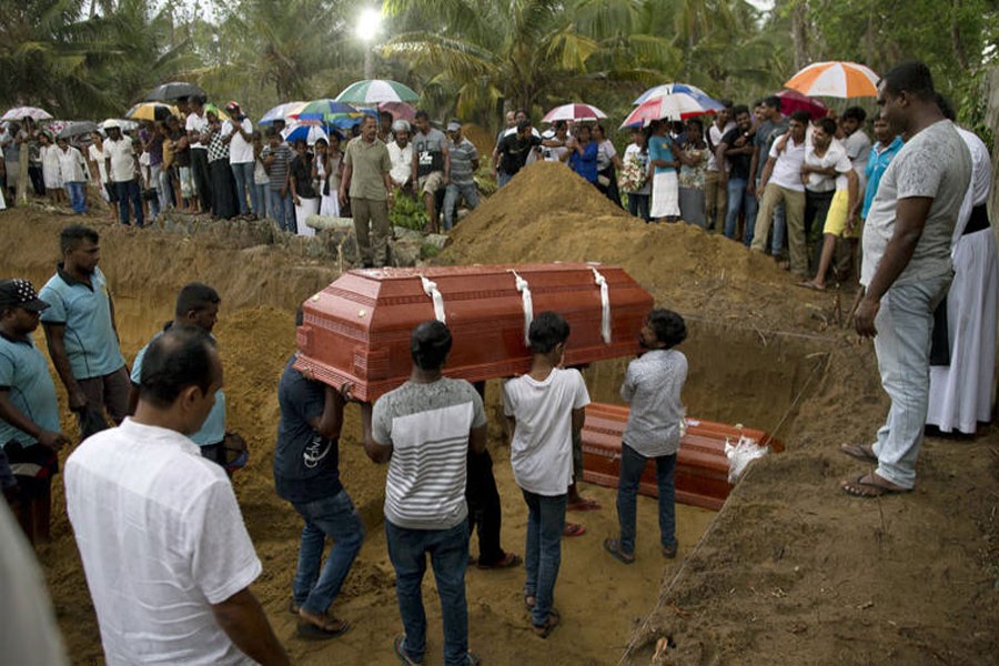 Relatives carry a coffin for burial during the funerals of three members of the same family, all died at Easter Sunday bomb blast at St Sebastian Church in Negombo, Sri Lanka, Monday, April 22, 2019. AP