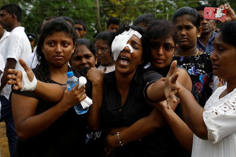 Kumari Fernando, who lost her husband, Dulip Fernando, and two children, Dulakghi and Vimukthi, during the bombing at St Sebastian's Church, yells towards the graves during a mass burial for victims at a cemetery near the church in Negombo in Sri Lanka, April 24, 2019. Reuters