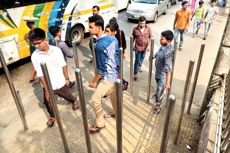 Authorities have installed steel bars to prevent motorcyclists from using the footpaths, but these are also impeding the movement of pedestrians. This photograph was taken from in front of Dhaka Shishu Park in the city on Saturday — FE photo by Shafiqul Alam