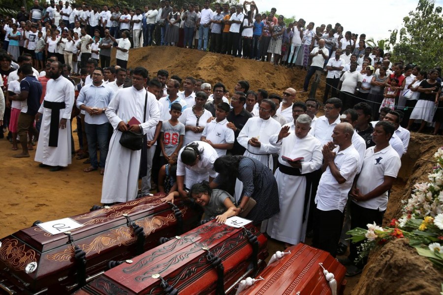 A woman reacts next to two coffins during a mass burial of victims, two days after a string of suicide bomb attacks on churches and luxury hotels across the island on Easter Sunday, at a cemetery near St Sebastian Church in Negombo, Sri Lanka, April 23, 2019. Reuters/File Photo