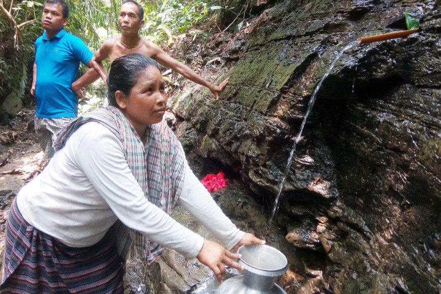 This photo shows how a woman collects water from a small stream at a remote area in Khagrachhari district