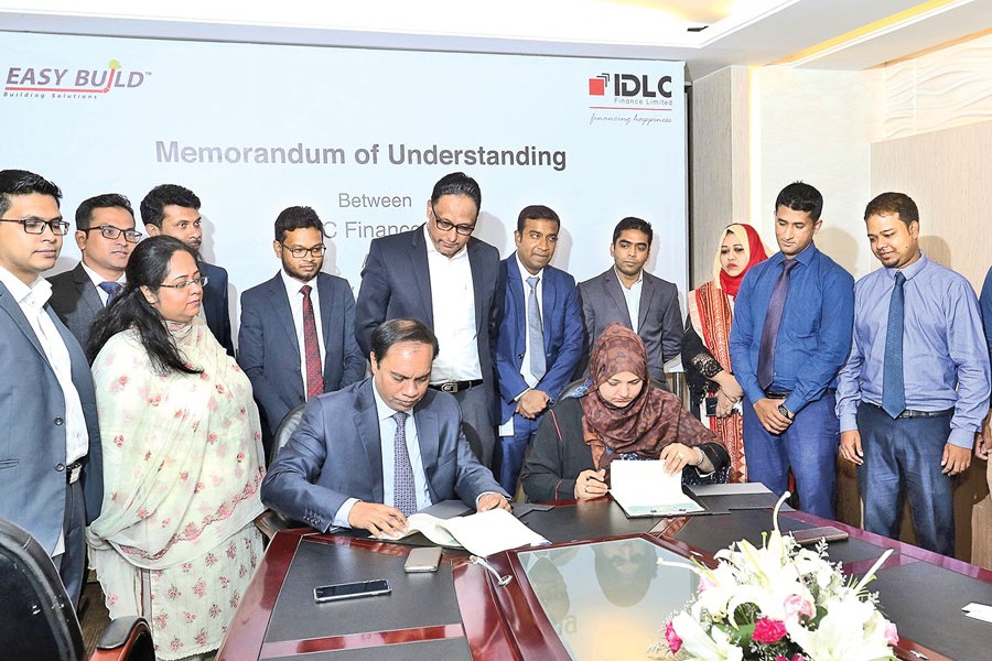 Jamal Uddin, Deputy Managing Director, IDLC Finance Limited, and Uzma Chowdhury, Director (Corporate Finance) of PRAN-RFL Group, signing an agreement at the head office of IDLC recently