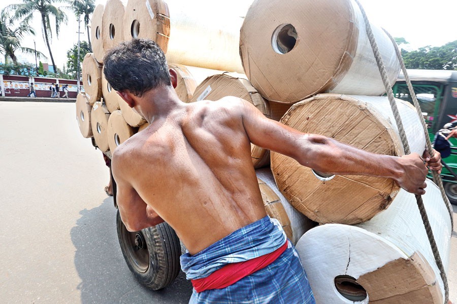 Pushcart labourers toiling hard defying scorching summer heat at Doel Chattar in the city on Friday — FE photo by KAZ Sumon