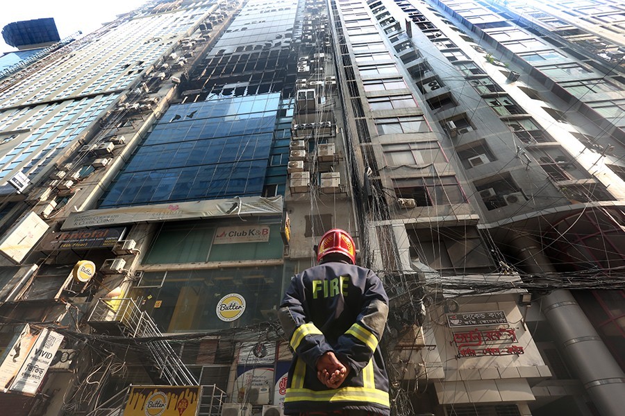 A firefighter stands outside the FR tower at Banani after putting out a deadly blaze that tore through several floors of the skyscraper, killing at least 26 people — FE photo