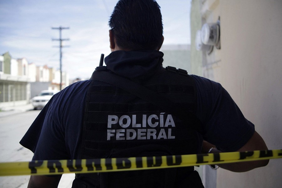 A federal police officer stands behind a police tape near a crime scene — Reuters/Files