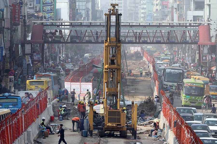 Metro-rail construction squeezes the scope of vehicular movement on the busy road from Mirpur to Agargaon in the capital, intensifying gridlock in the areas.— FE Photo by KAZ Sumon