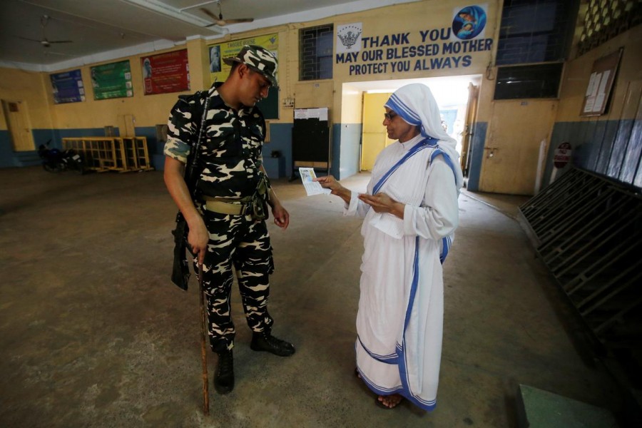 A security personnel checks an identity card of a catholic nun from the Missionaries of Charity as she arrives to cast her vote at a polling station during the final phase of general election in Kolkata, India on May 19, 2019 — Reuters photo