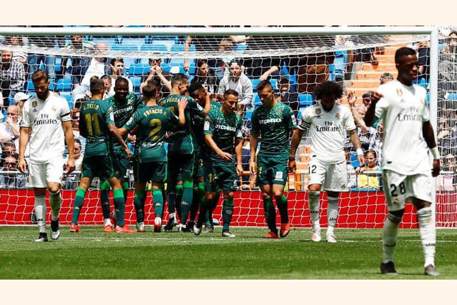 Real Betis' Jese celebrating with teammates after scoring their second goal as Real Madrid's Nacho and Marcelo look dejected on Sunday	— Reuters