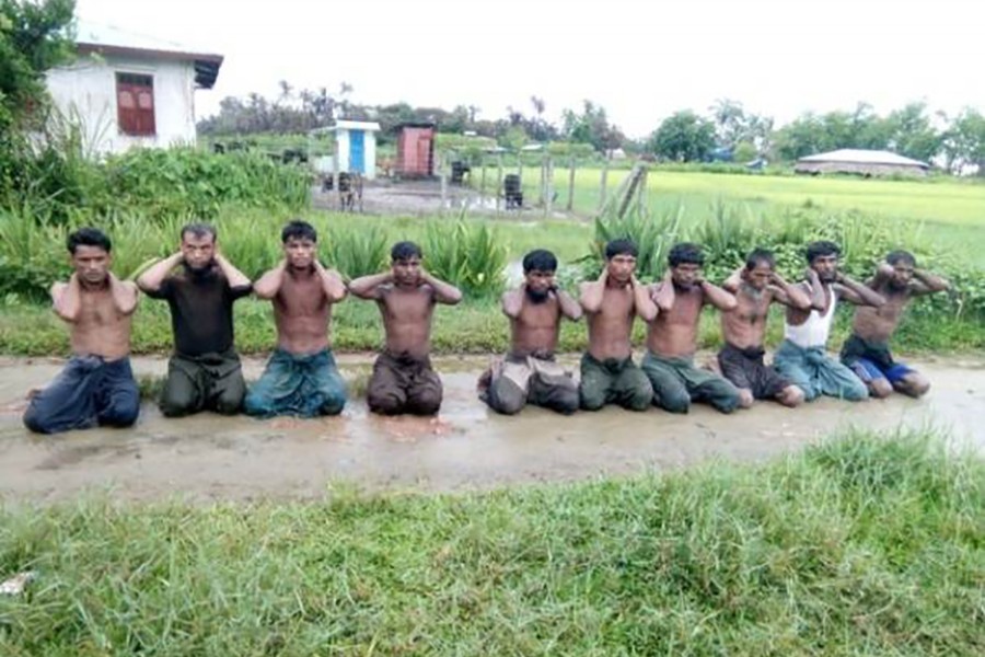 Ten Rohingya Muslim men with their hands bound kneel in Inn Din village, Myanmar on September 1, 2017 — Handout via Reuters