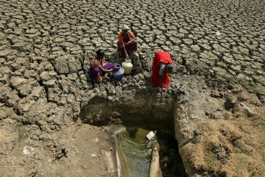 Women fetch water from an opening made by residents at a dried-up lake in Chennai, India, June 11, 2019. Reuters/Files