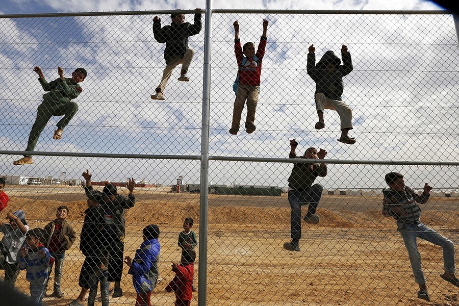 Syrian refugee children climb a fence to watch a football training workshop in Azraq refugee camp, near Al Azraq city, Jordan, on November 16, 2015 — Reuters/Files