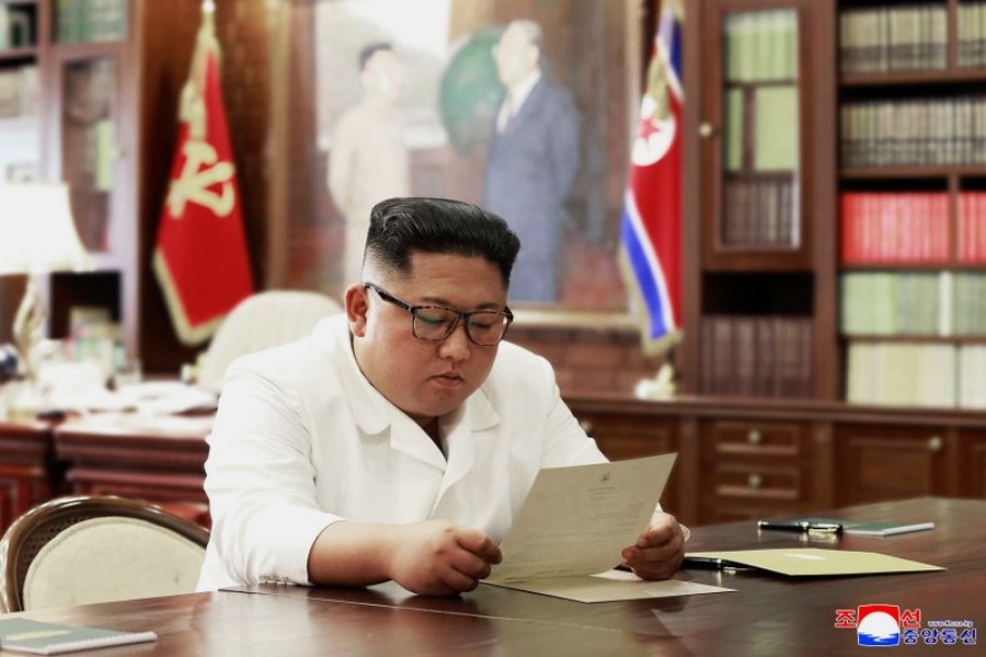 In this undated photo provided on Sunday, June 23, 2019, by the North Korean government, North Korean leader Kim Jong Un reads a letter from US President Donald Trump. (Korean Central News Agency/Korea News Service via AP)