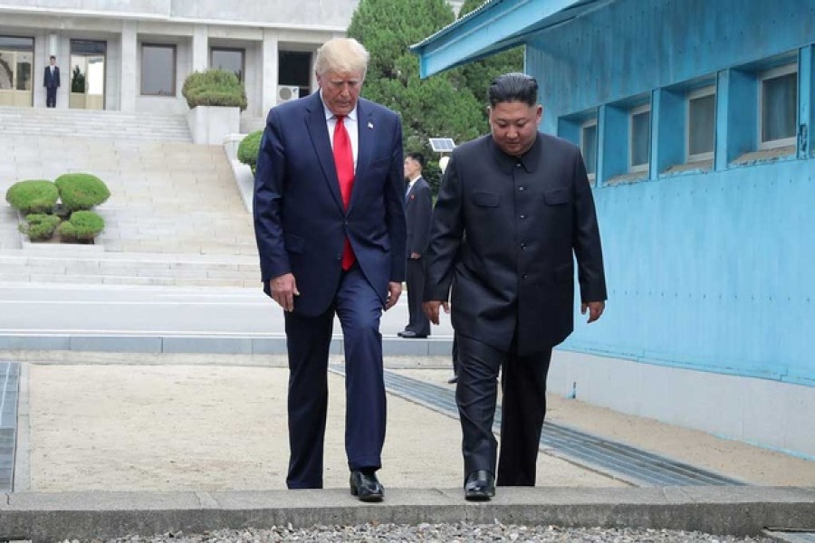 Trump-Kim meeting: US President Donald Trump and North Korean leader Kim Jong Un cross over a military demarcation line at the demilitarised zone (DMZ) separating the two Koreas, in Panmunjom, South Korea, June 30, 2019. KCNA via Reuters