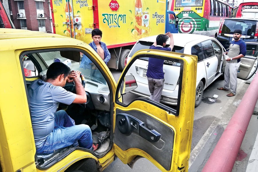 A driver sitting at the steering tired on the Malibagh flyover on Tuesday as his car gets stuck in a massive traffic jam caused by blockade of roads by enraged rickshaw-pullers protesting the ban on the movement of tricycles on three major roads of the city — FE photo by KAZ Sumon