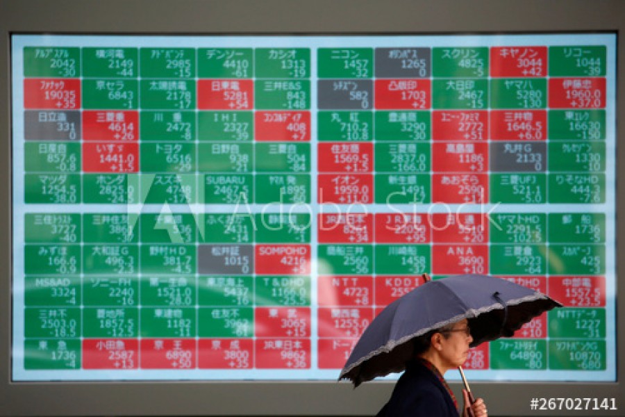 A passerby walks past in front of a stock quotation board outside a brokerage in Tokyo, Japan, May 10, 2019. Reuters/Files