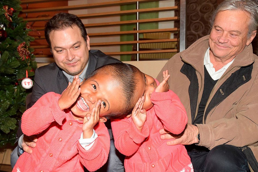 In this Jan. 7, 2019 photograph provided by Action for Defenceless People Foundation, Hungarian doctors Gergely Pataki, left, and Andras Csokay pose together with Rabeya and Rukaya, two Bangladeshi girls who were born conjoined at the head in Budapest, Hungary - Miklos Bemer/Action for Defenceless People Foundation via AP