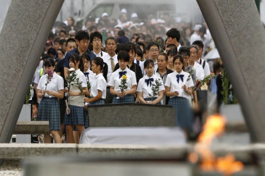 People pray for the atomic bomb victims in front of the cenotaph at the Hiroshima Peace Memorial Park in Hiroshima on Aug 6, 2019- Kyodo News/AP