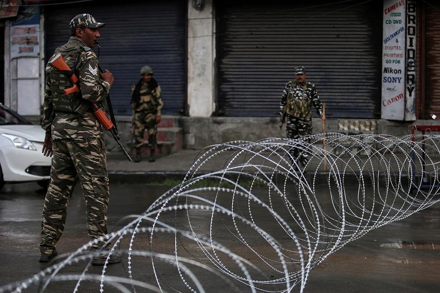 Indian security forces personnel stand guard next to concertina wire laid across a road during restrictions after the government scrapped special status for Kashmir, in Srinagar on August 7, 2019 — Reuters/Files