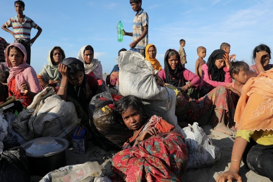 Exhausted Rohingya refugees rest after arriving by a wooden boat from Myanmar to the shore of Shah Porir Dwip, in Teknaf, near Cox's Bazar in Bangladesh, October 1, 2017. Reuters/Files