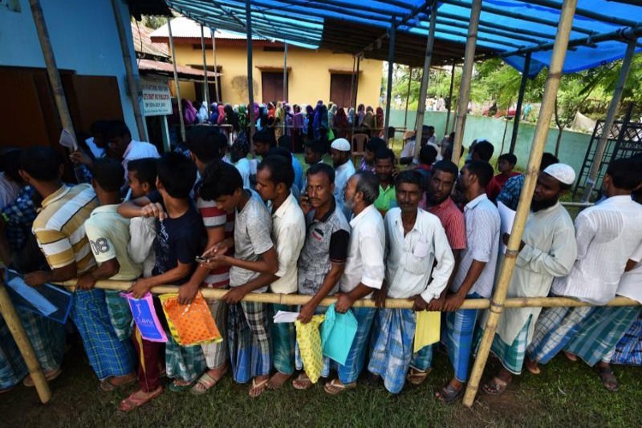 People wait in queue to check their names on the draft list at the National Register of Citizens (NRC) centre at a village in Nagaon district, Assam state, India, July 30, 2018. Reuters