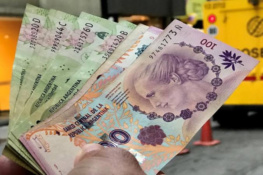 FILE PHOTO: A man shows Argentine pesos outside a bank in Buenos Aires' financial district, Argentina August 30, 2018. REUTERS/Marcos Brindicci/File Photo