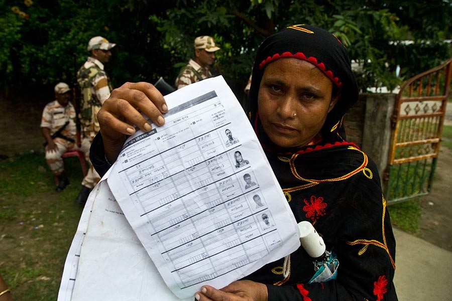 A woman displaying a document that shows inclusion of her name in the final list of the National Register of Citizens (NRC) in the Indian state of Assam on August 31, 2019. —AP Photo