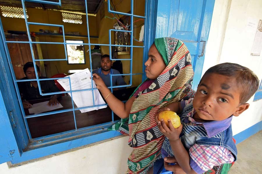 The file photo shows a woman, along with her son, trying to check her name on the draft list of the National Register of Citizens (NRC) at an NRC centre in the northeastern state of Assam, India. -Reuters Photo