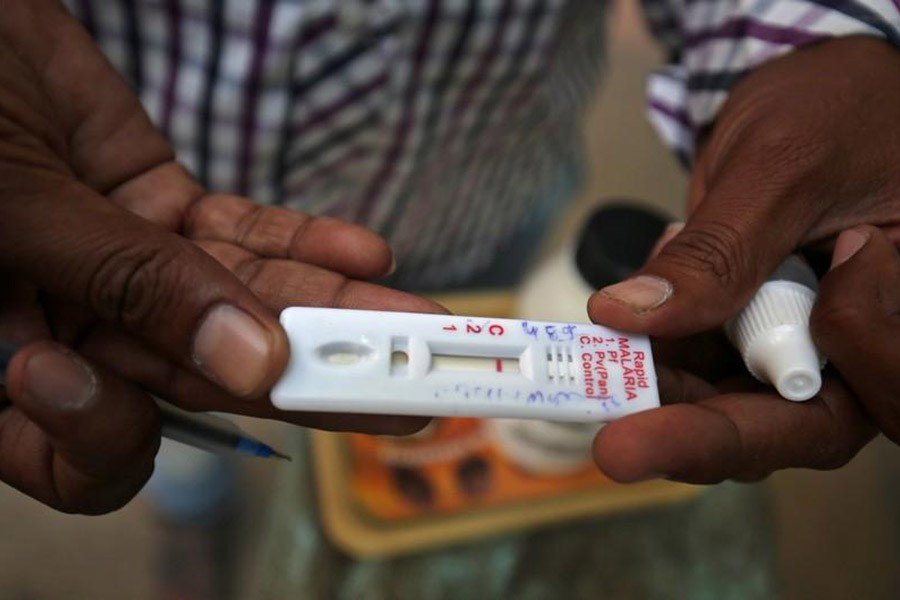 A health worker showing a malaria rapid test kit after collecting blood sample from a resident during a drive to prevent the spread of mosquito-borne diseases. -Reuters Photo