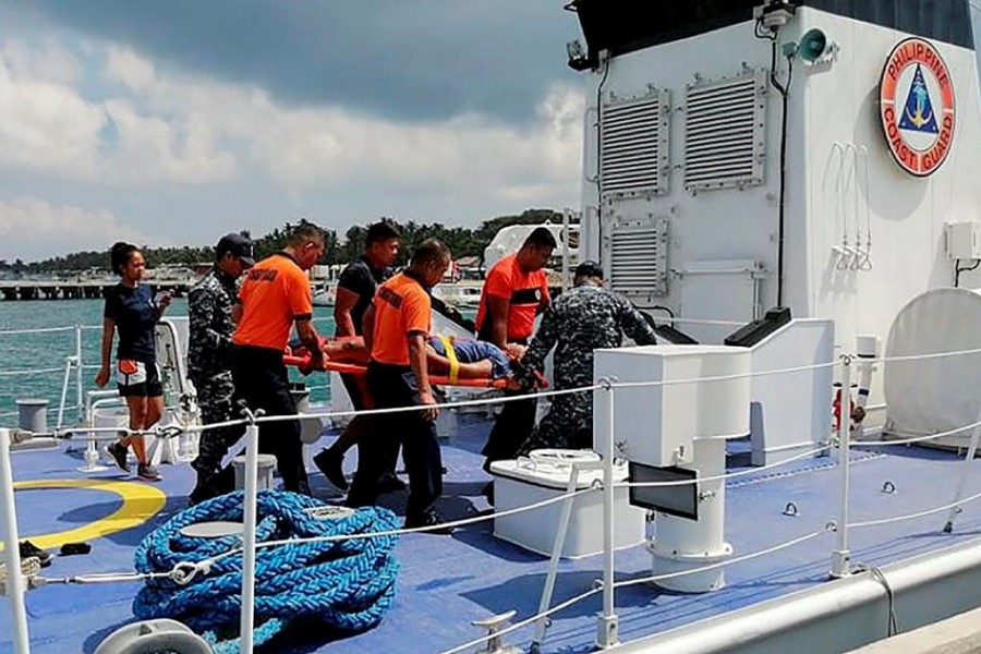 n this photo provided by Philippine Coast Guard in Manila, coast guard personnel carry a survivor to a waiting ambulance after being rescued from a capsized dragon boat off Boracay island resort Wednesday, Sept. 25, 2019, in the central Philippines. (Philippine Coast Guard Via AP)