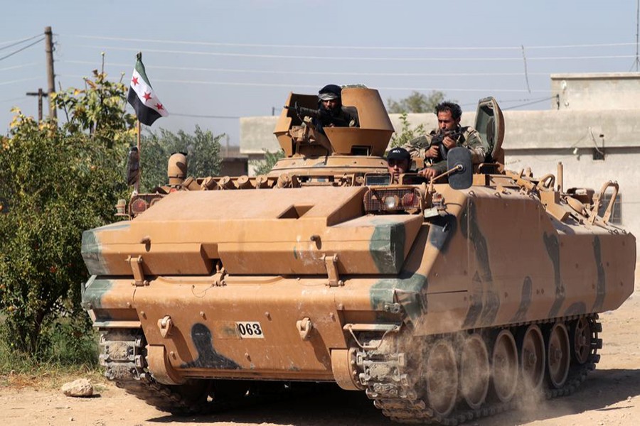 Turkey-backed Syrian rebel fighters ride on a military truck near the border town of Tel Abyad, Syria on October 12, 2019 — Reuters photo